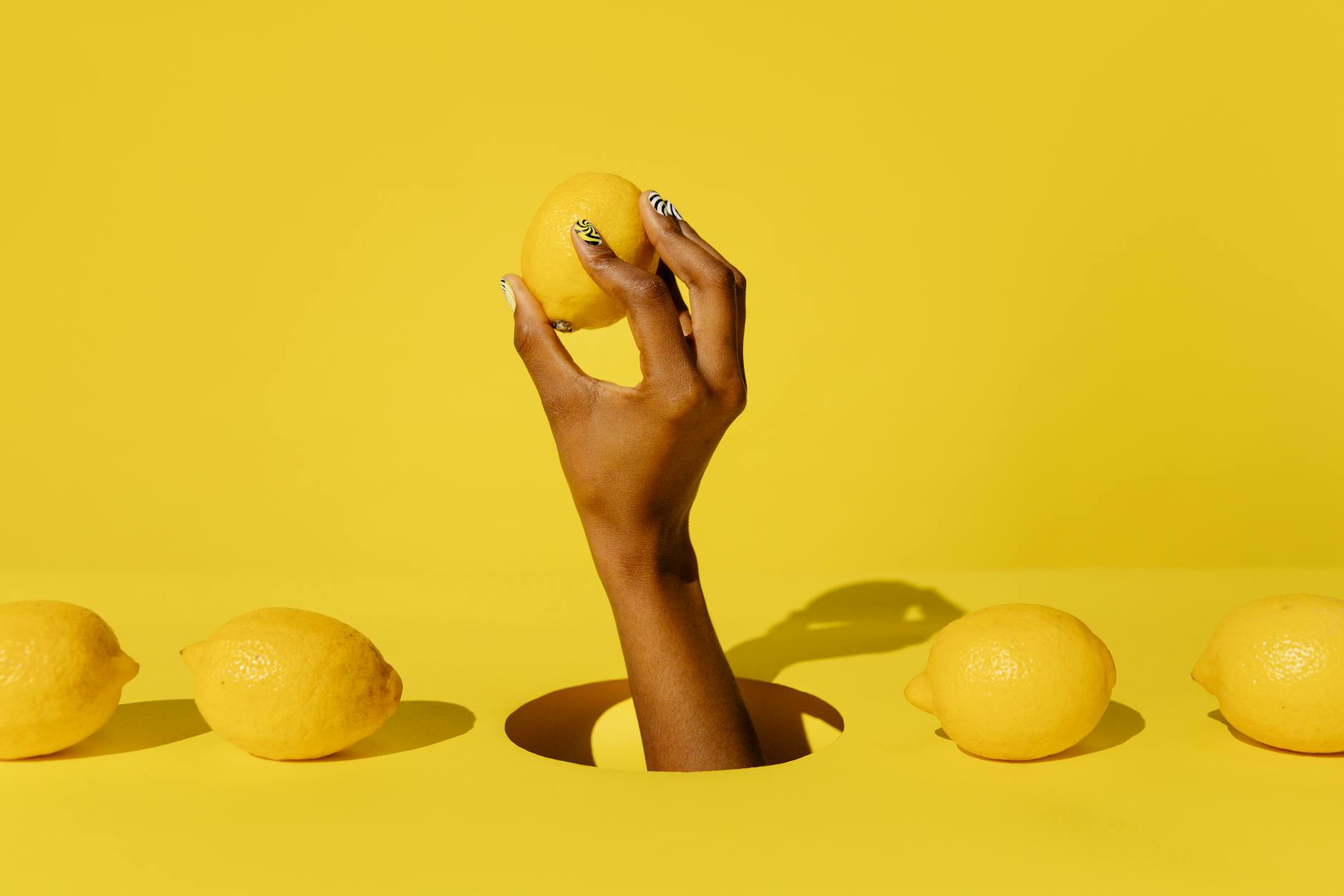 A fresh lemon held against a bright yellow background, symbolizing new approaches to intimacy