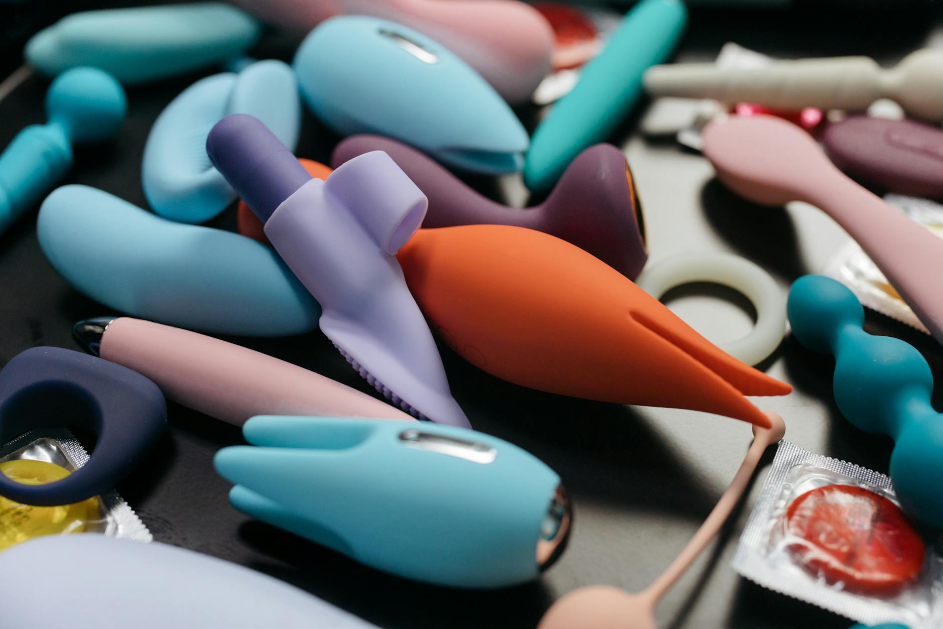 Woman holding silicone vibrators in contemplative moment