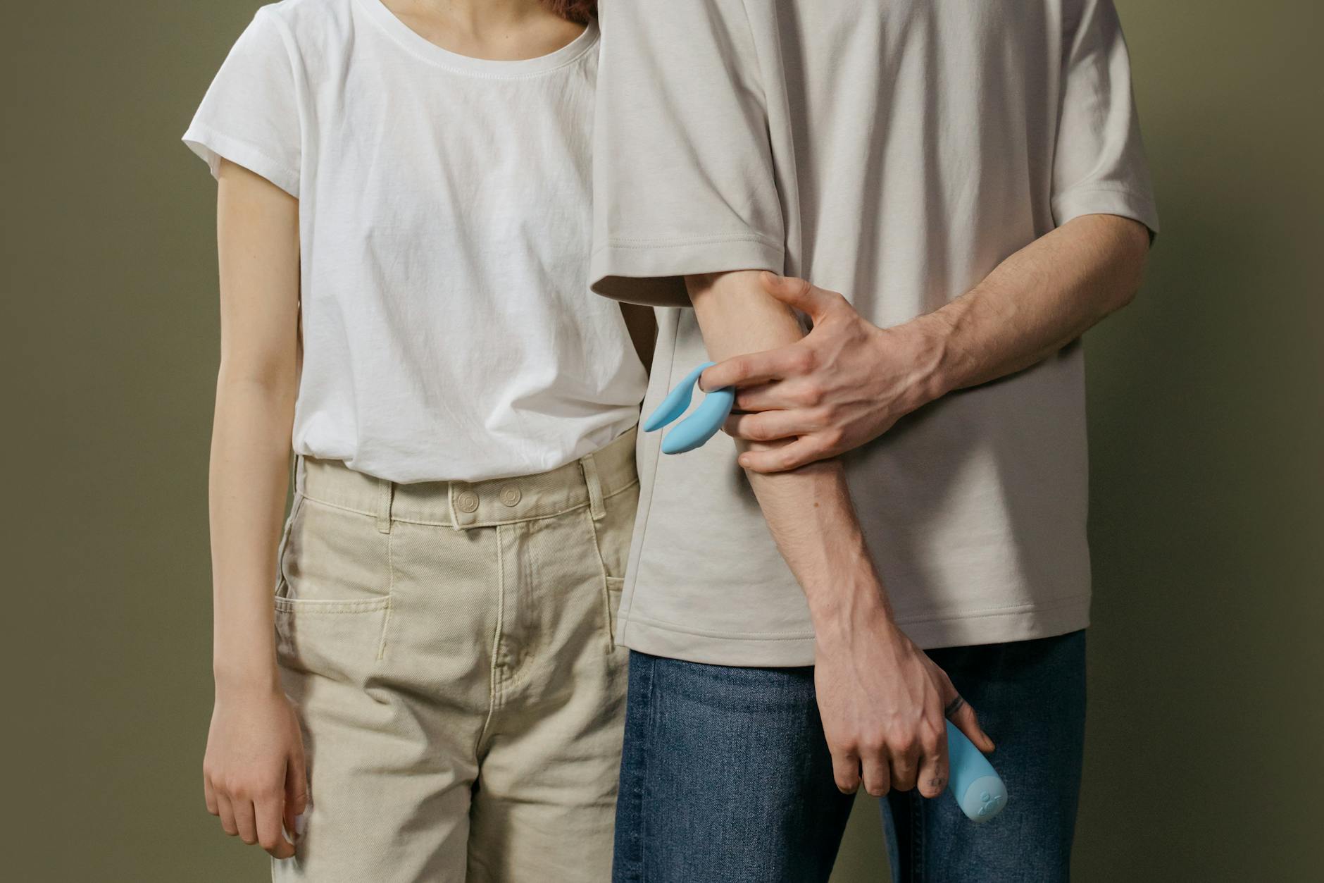 A couple exploring intimacy together with a blue vibrator, representing modern approaches to pleasure after hormonal changes.